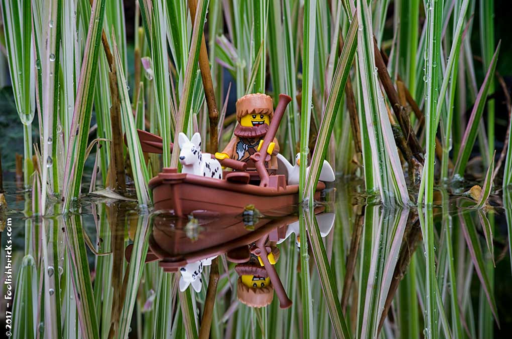 Lego photography - A huntsman with his dog in the water on a clear day.