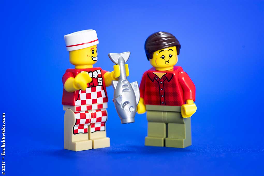 lego cook shows fish to nauseous disgusted man