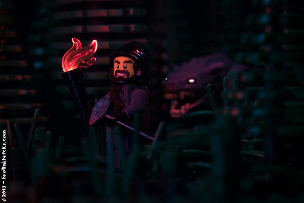 lego man with a torch in a dark forest with wolves